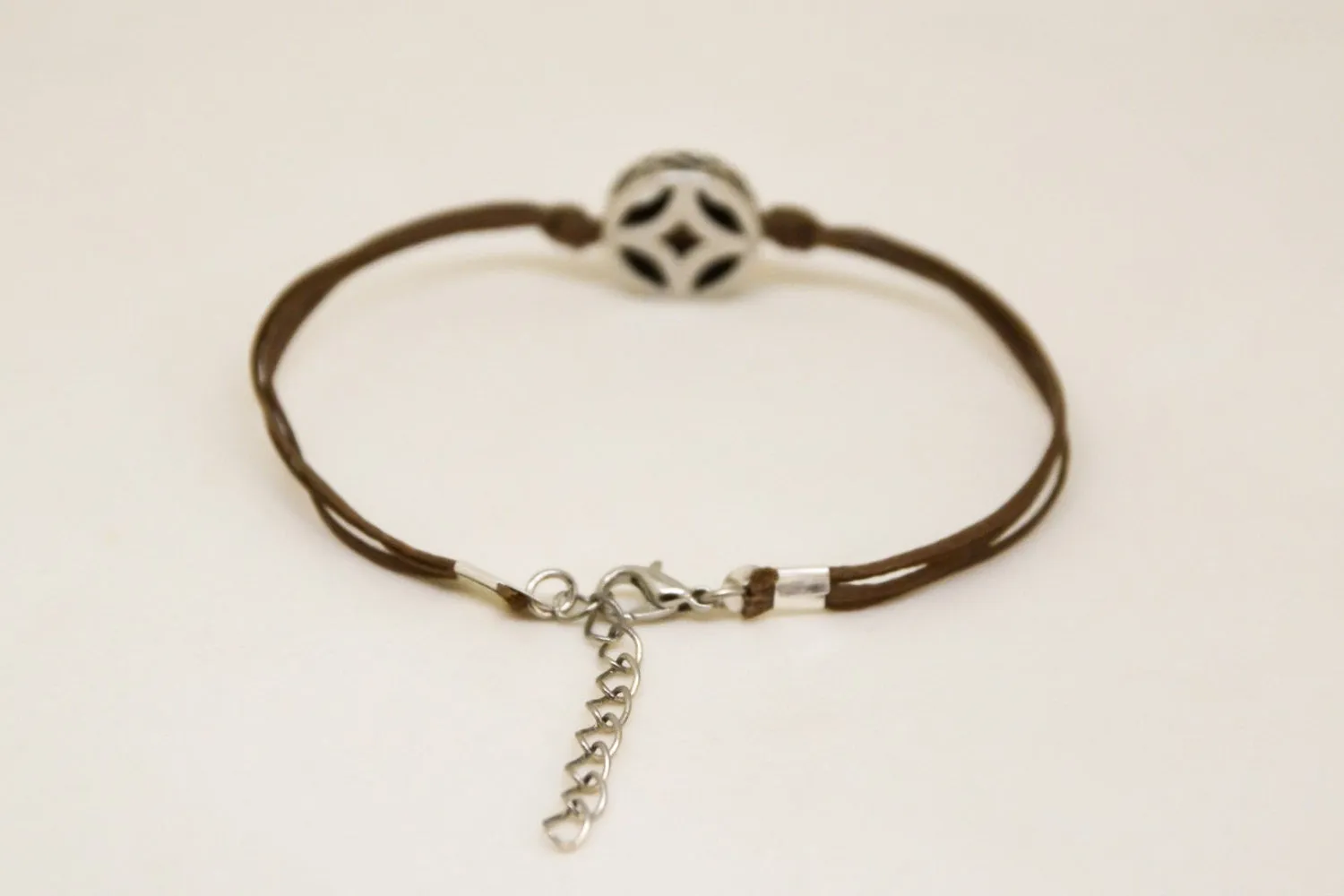 Brown cord bracelet with decorated silver circle bead charm