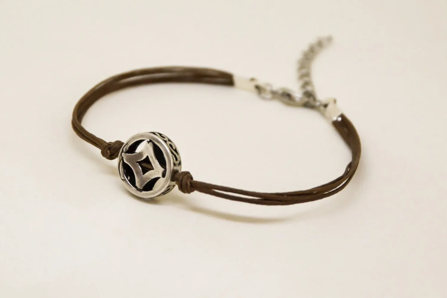 Brown cord bracelet with decorated silver circle bead charm